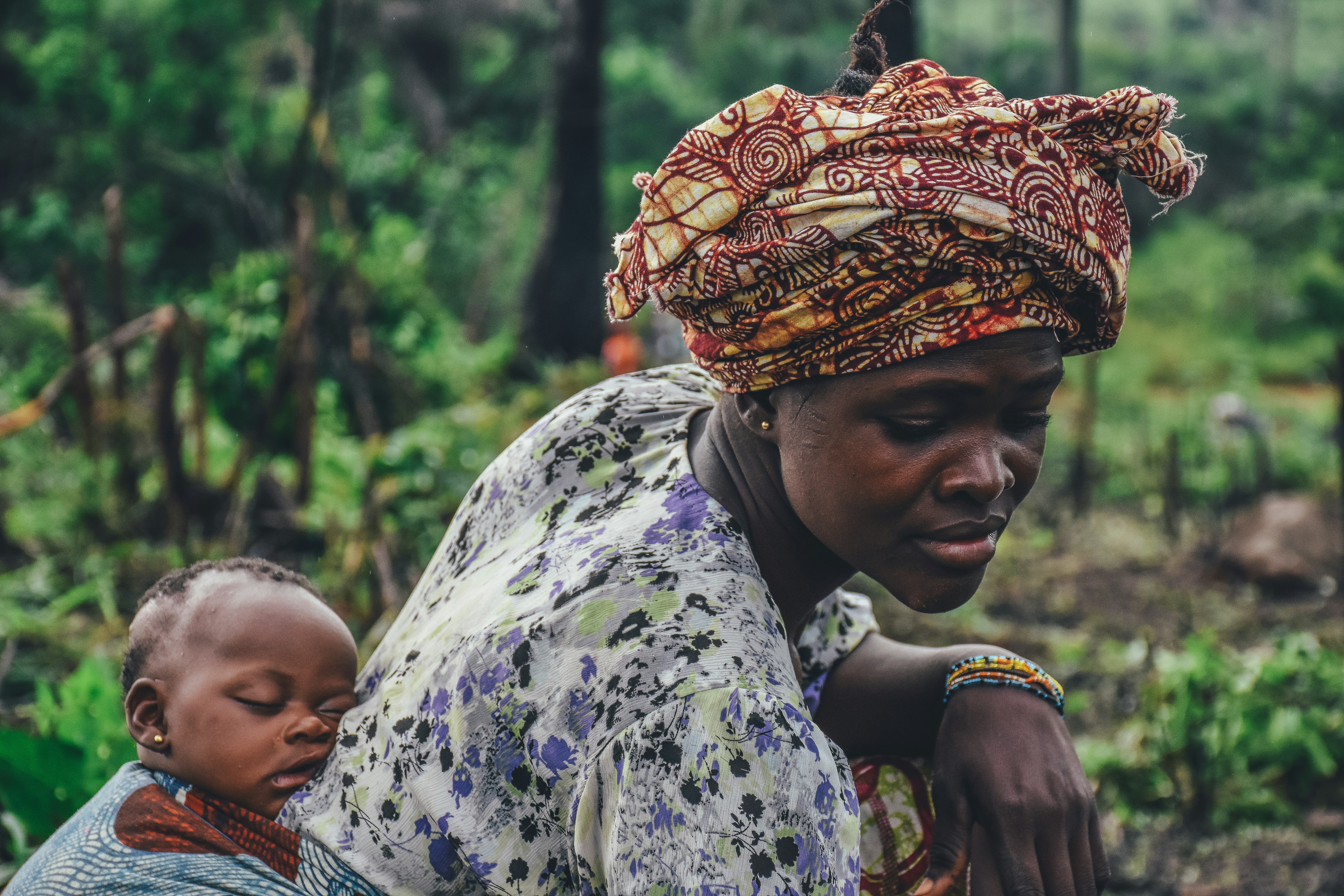 African woman farming with child - sustainable agriculture